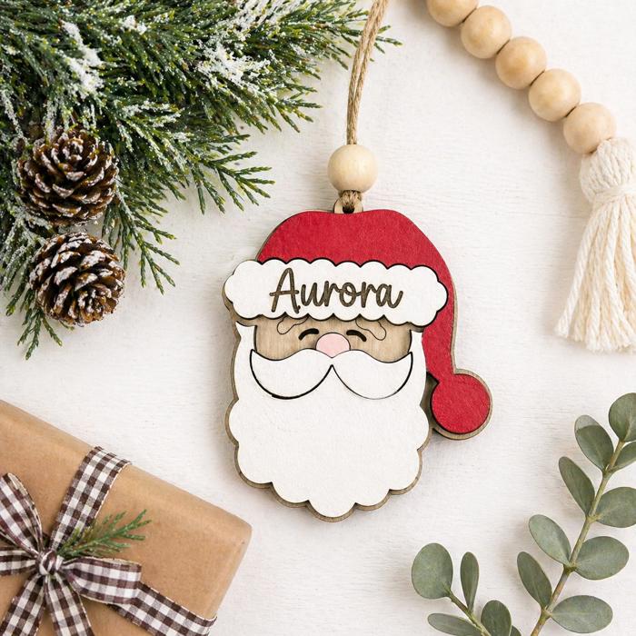 Personalized Santa Claus Ornament  Size: 4''X4.5''  This ornament is laser cut with two layer giving the ornament a 3D look, the name is engraved  It arrives ready to hang with twine string and one wo