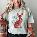Small Bay Light Sage Rabbit Folk Art Inspired Scandinavian Winter Christmas Scene Art Comfort Colors Tee