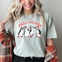 Small Bay Light Sage Jolly Holiday Penguins Christmas Parade In Cozy Winter Village Scene With Snowflakes And Cheer Comfort Colors Tee