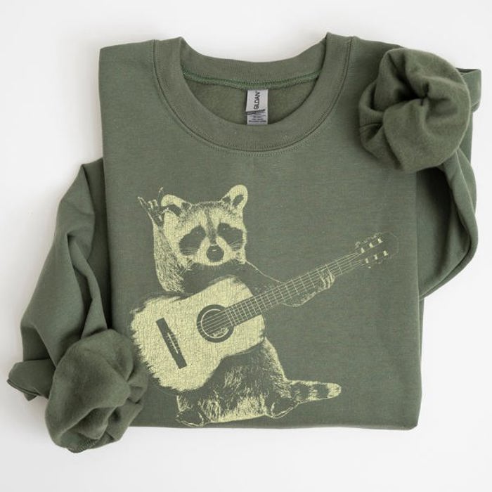 Raccoon Playing A Guitar In A Whimsical Forest Scene With Playful Vibe Sweatshirt