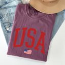 Medium Berry Red USA Flag Patriotic American Pride Print Emblem With Bold Stars And Stripes Across The Banner Comfort Colors Tee