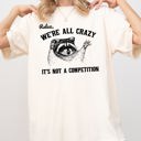 Small Ivory Cream Relax, We're All Crazy, It's Not a Competition Raccoon Mental Health Positivity Comfort Colors Tee