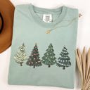 Large Bay Light Sage Classic Christmas Trees Winter Snow Santa Holiday Scene Cozy Timeless Festive Vintage Charm Comfort Colors Tee
