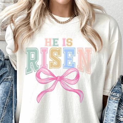 He Is Risen Pastel Varsity Tee with Pink Bow, Preppy Easter Shirt, Colorful Christian Spring Graphic Tee, Women’s Easter Outfit